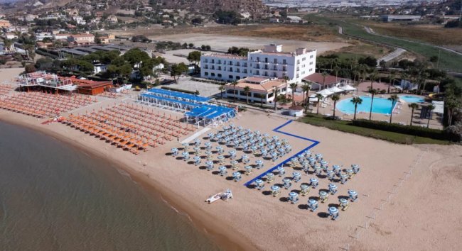 Stabilimento balneare con file di ombrelloni colorati.