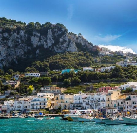 Panorama costiero con edifici e barche sul mare.