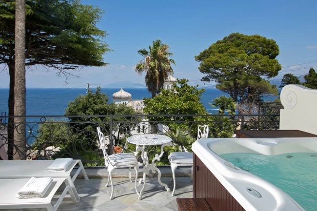 Terrazza con idromassaggio, tavolo e vista panoramica.