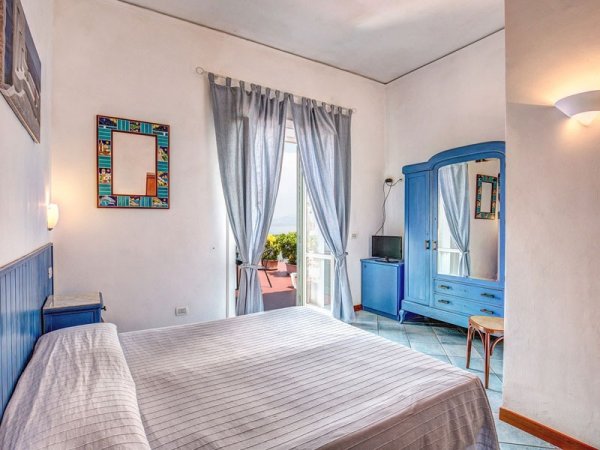 Camera da letto con arredi blu.