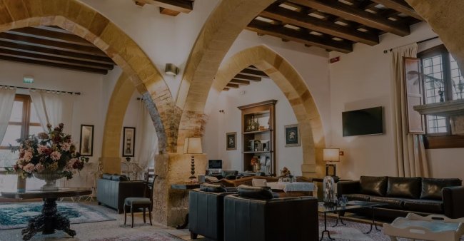 Soggiorno con archi in pietra e arredi eleganti.