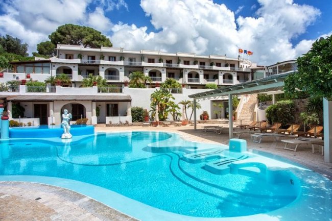 Piscina all'aperto con edificio sullo sfondo.