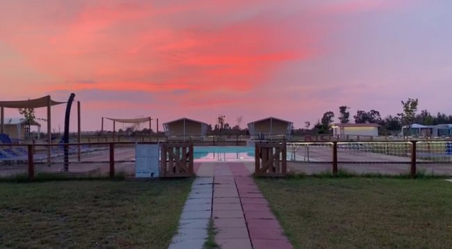 Piscina al tramonto con cielo rosa.