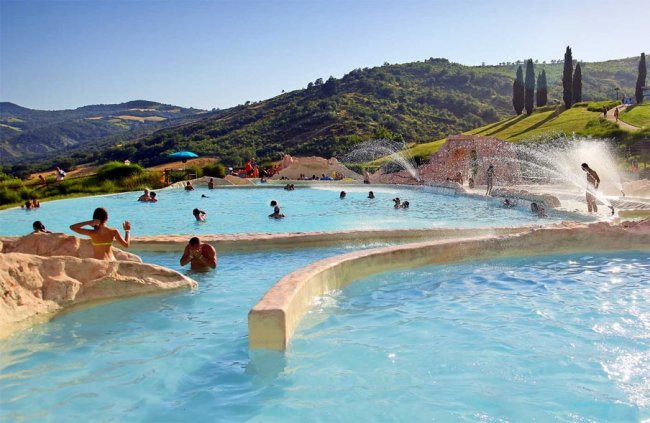 Piscina termale all'aperto con colline sullo sfondo.
