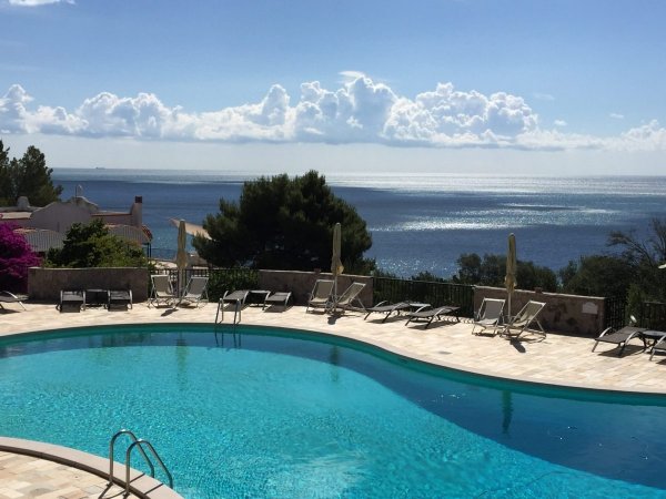 Piscina curvilinea con vista sul mare.