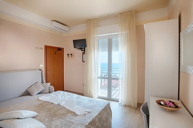 Camera da letto luminosa con vista mare.