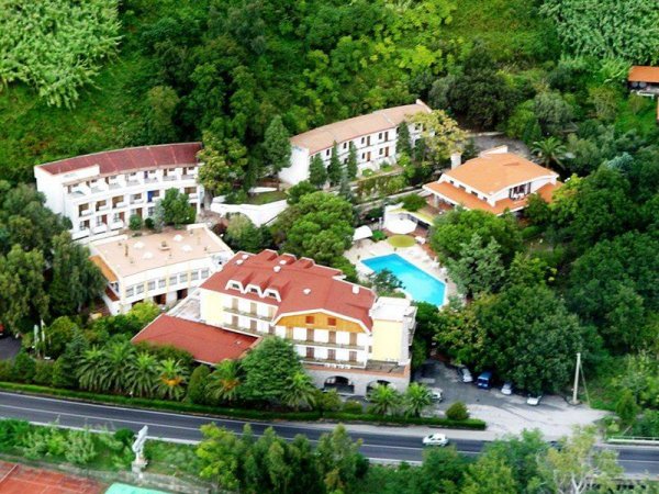 Vista aerea di un hotel circondato da vegetazione.