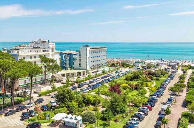Vista panoramica di un lungomare con edifici e auto parcheggiate.