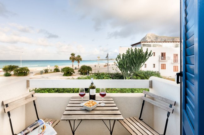 Balcone con tavolo e sedie, vista mare.