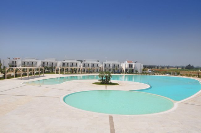 Piscina grande con edifici bianchi.