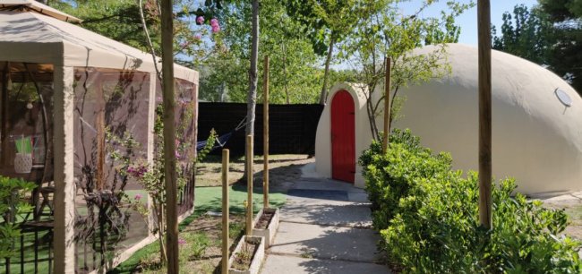 Capanno con tetto rosso in un giardino verde.