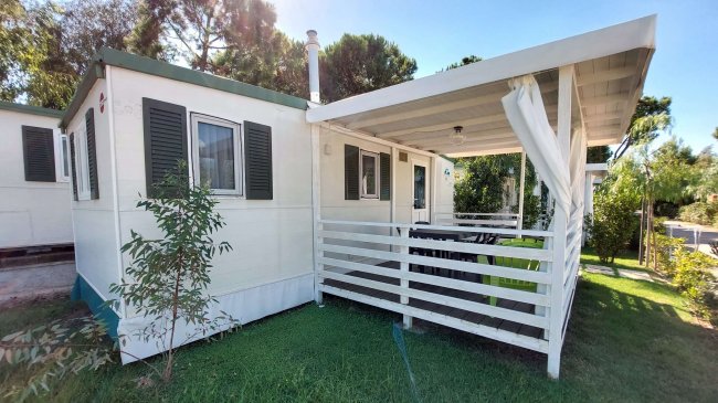 Casa mobile con veranda in giardino verde.
