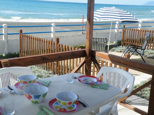 Tavolo apparecchiato su veranda fronte mare.