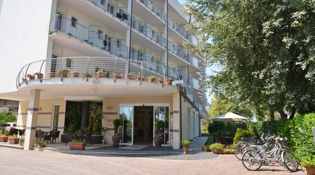 Esterno di un hotel moderno con balconi e biciclette.
