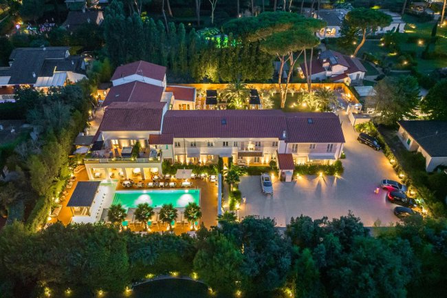 Vista aerea di una villa con piscina illuminata.