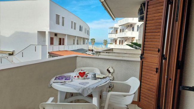 Balcone con tavolo e sedie, vista mare.