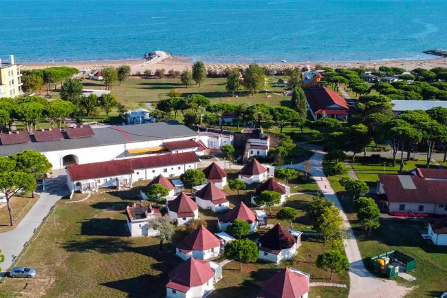 Vista aerea di villaggio con casette vicino al mare.