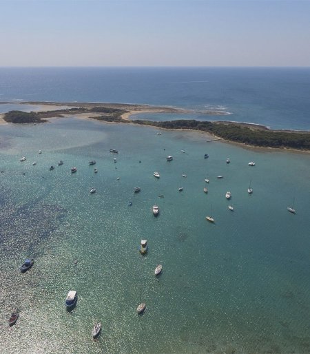 Vista aerea di barche in mare vicino a una costa.