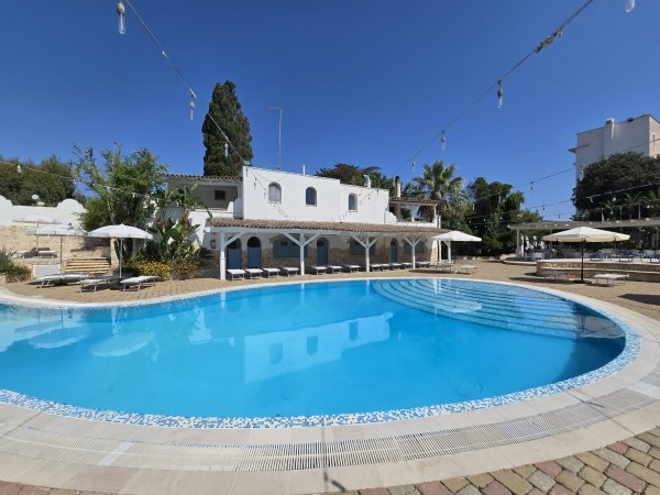 Piscina circondata da ombrelloni e lettini.