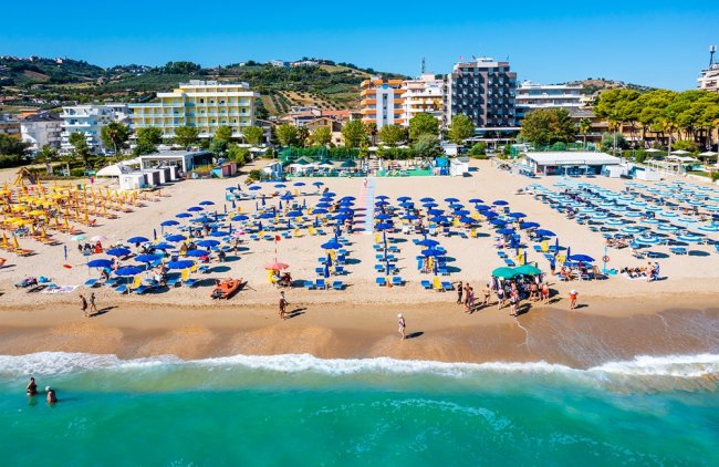 Spiaggia con ombrelloni e mare in primo piano.