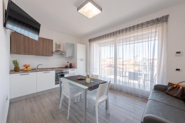 Cucina luminosa con tavolo e sedie.