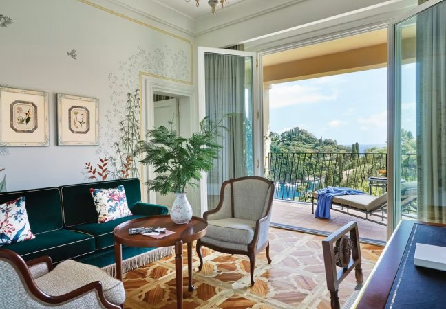 Salotto elegante con balcone affacciato sul paesaggio.