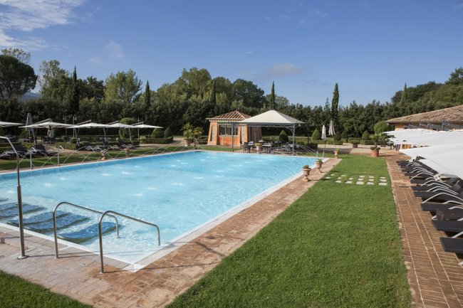 Piscina scoperta con lettini e ombrelloni.