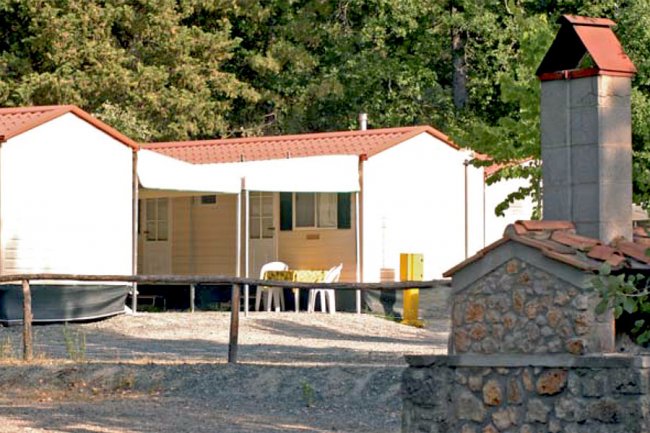 Bungalow con tetto rosso in un contesto rurale.