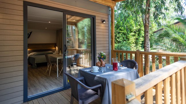 Terrazza con tavolo apparecchiato e porta scorrevole.