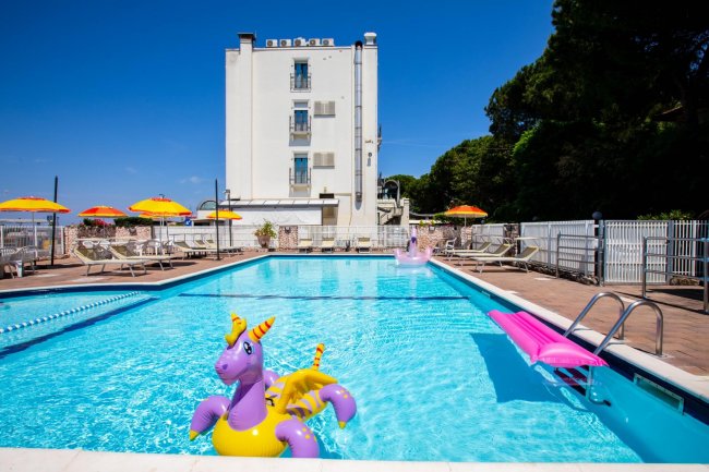 Piscina con gonfiabile viola e ombrelloni arancioni.