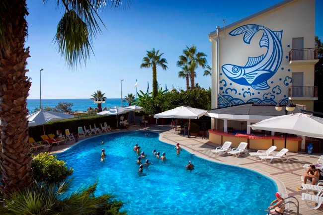 Piscina esterna con persone e murale.