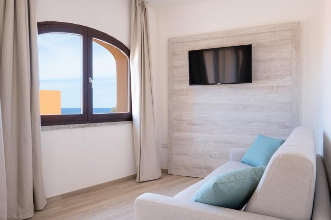 Soggiorno con finestra ad arco e TV.