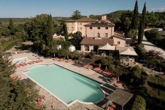 Piscina esterna con lettini in un complesso ricettivo.