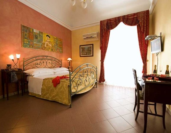 Camera con letto matrimoniale, pareti colorate e decorazioni eleganti.