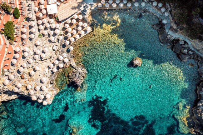 Spiaggia con ombrelloni e mare turchese.