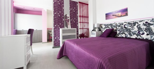 Camera con letto viola e arredo moderno.