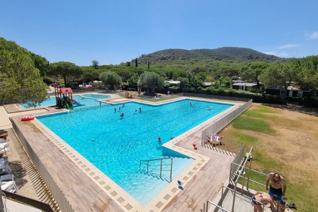Ampia piscina all'aperto, persone che nuotano.