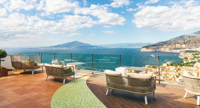 Terrazza panoramica con divani e vista mare.