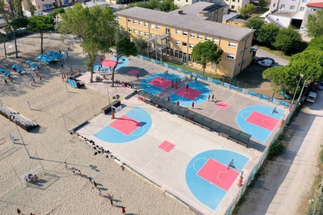 Veduta dall'alto di campi da basket e spiaggia sabbiosa.