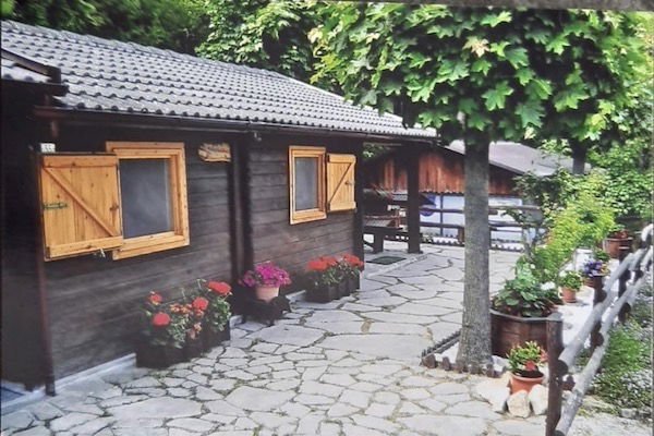 Chalet rustico con vasi di fiori lungo il sentiero.