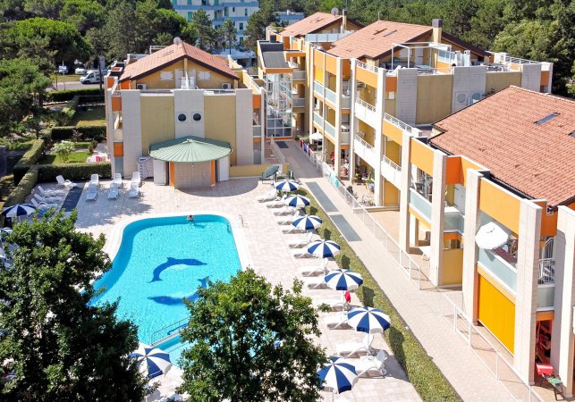 Piscina con lettini e ombrelloni blu a bordo.