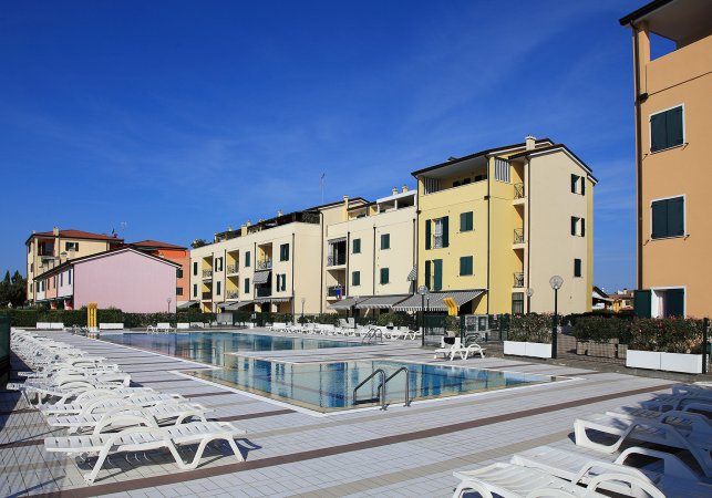 Ampia piscina circondata da edifici colorati.