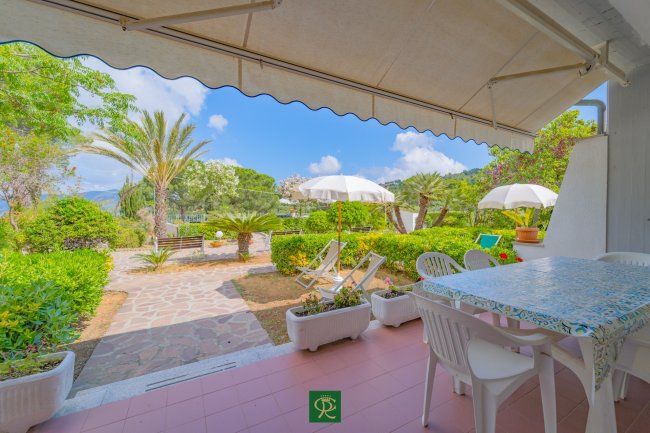 Terrazza con tavolo e ombrelloni bianchi.