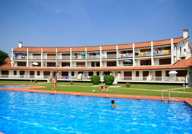 Piscina con villette a schiera e prato.