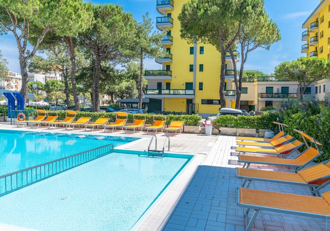 Piscina all'aperto con lettini arancioni.