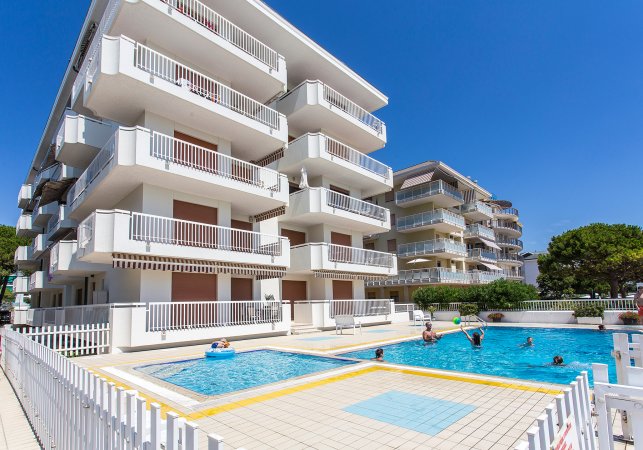 Edificio con piscine all'aperto, persone che nuotano.