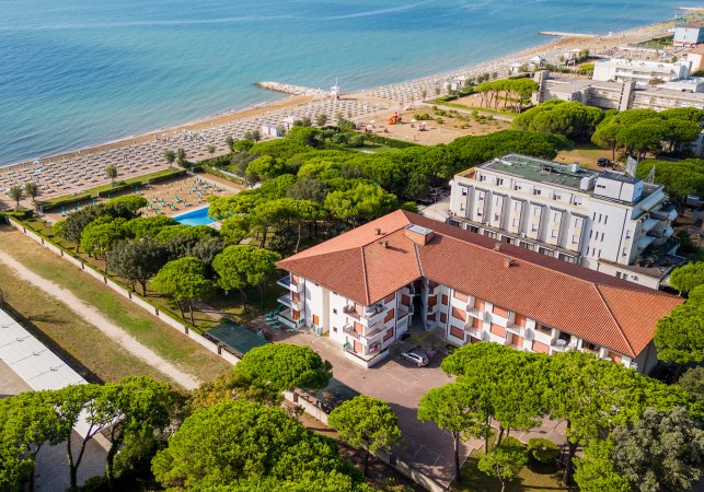 Edificio vicino al mare, circondato da alberi.