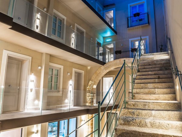 Interno moderno con scale e balconi illuminati.