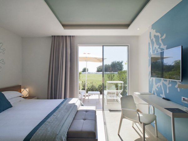 Camera moderna con porta finestra che dà sul giardino.