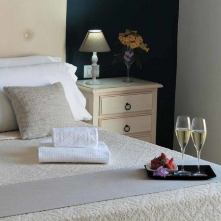 Letto con asciugamani, lampada e calici.